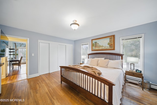 bedroom featuring a closet, baseboards, and wood finished floors