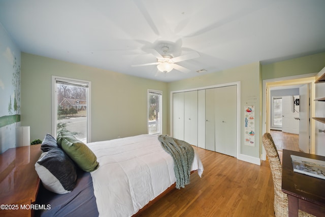 bedroom with visible vents, a closet, wood finished floors, and a ceiling fan