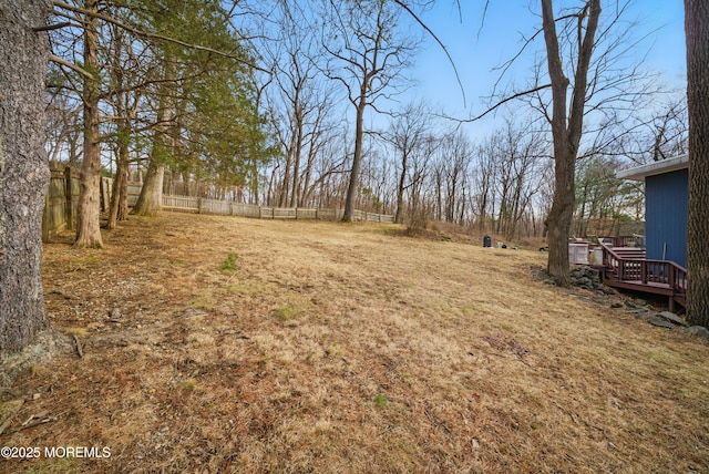 view of yard with a wooden deck and fence