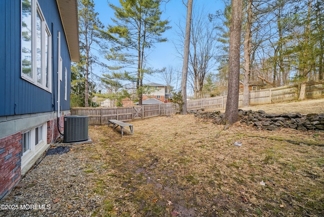 view of yard with a fenced backyard and central air condition unit