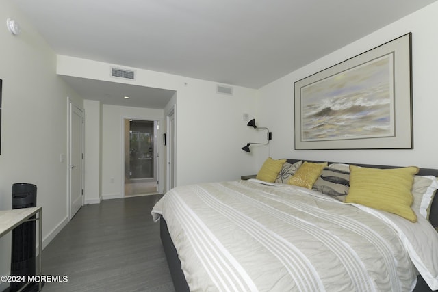 bedroom featuring dark wood finished floors, visible vents, and baseboards