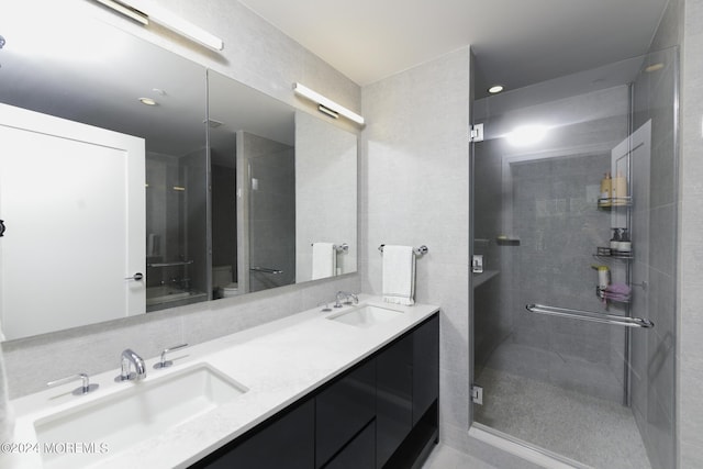 bathroom with double vanity, a sink, toilet, and an enclosed shower