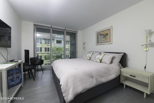 bedroom with access to exterior, floor to ceiling windows, and wood finished floors