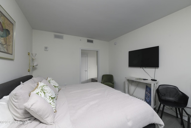 bedroom featuring visible vents and wood finished floors