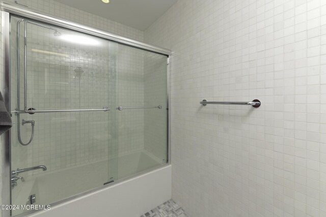 bathroom featuring enclosed tub / shower combo and tile walls