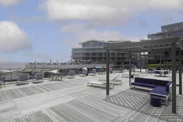 wooden deck featuring a water view and an outdoor living space