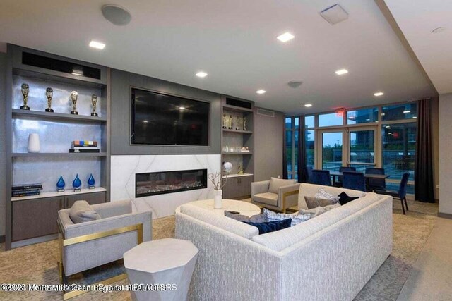 living area featuring a premium fireplace, recessed lighting, and built in features