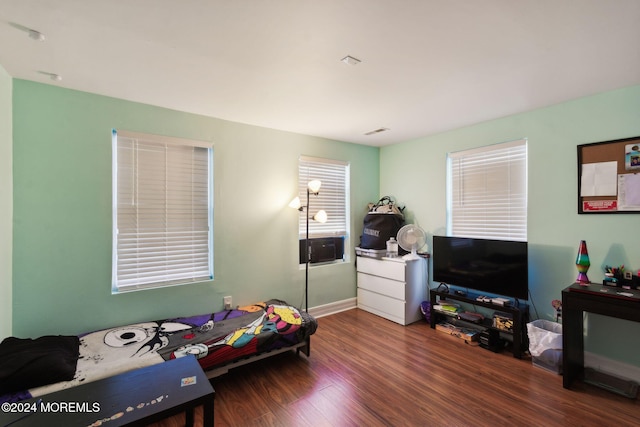 bedroom featuring wood finished floors and visible vents