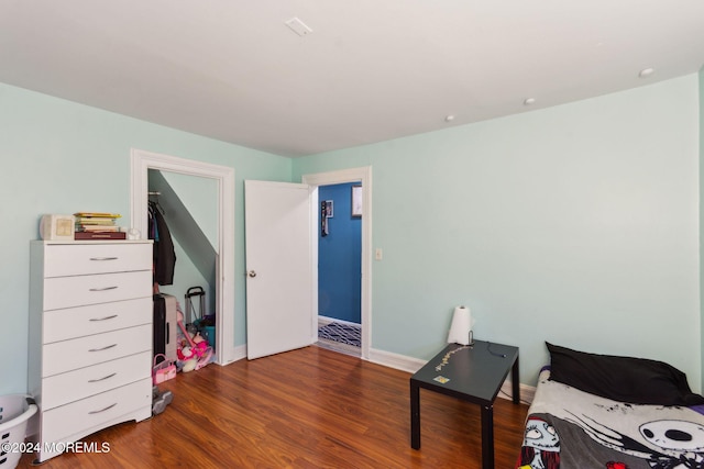 bedroom with baseboards and wood finished floors