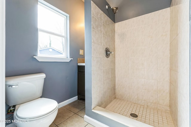 bathroom with tiled shower, tile patterned flooring, and toilet