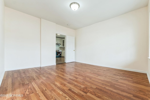 unfurnished room featuring baseboards and wood finished floors