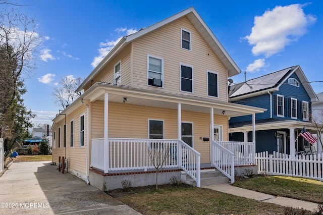 view of front of house featuring covered porch and fence