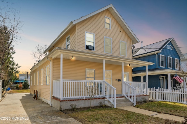 view of front of home with a porch and fence