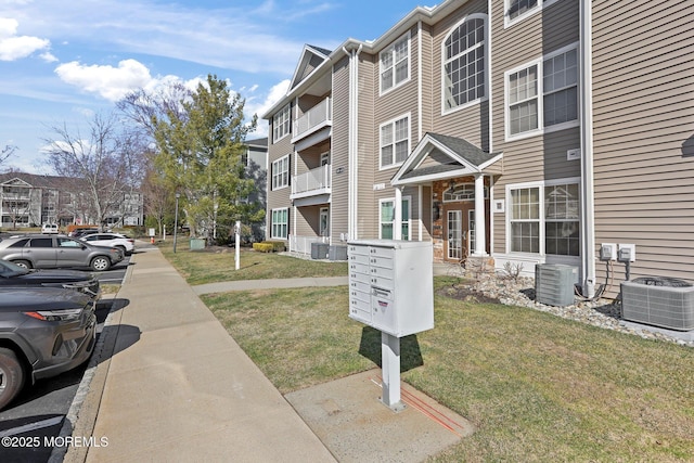 view of property with central AC unit, a residential view, and uncovered parking