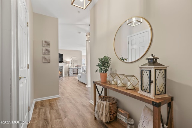 corridor featuring baseboards and wood finished floors