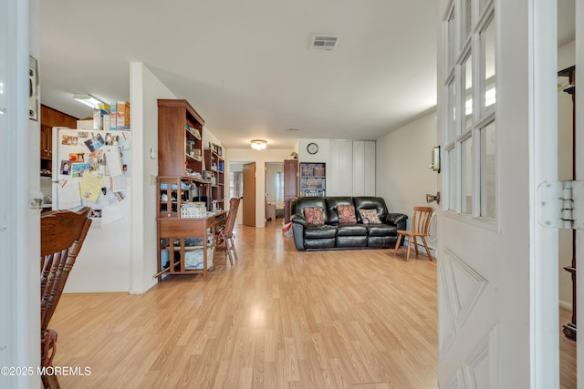 living area with visible vents and light wood-style floors