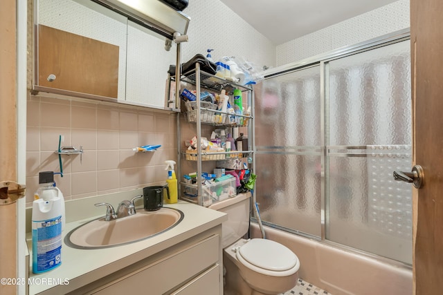 bathroom featuring shower / bath combination with glass door, tile walls, backsplash, toilet, and vanity