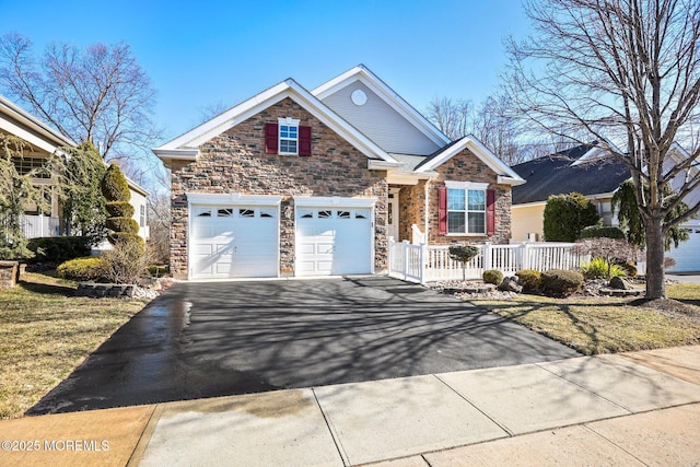 view of front of property with aphalt driveway, an attached garage, and fence