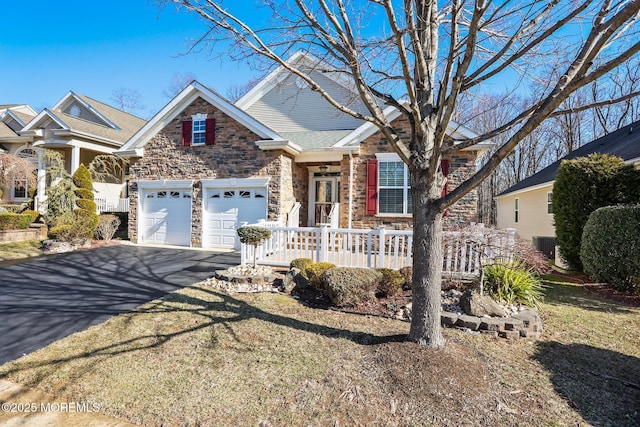 view of front of property with aphalt driveway, a garage, and stone siding