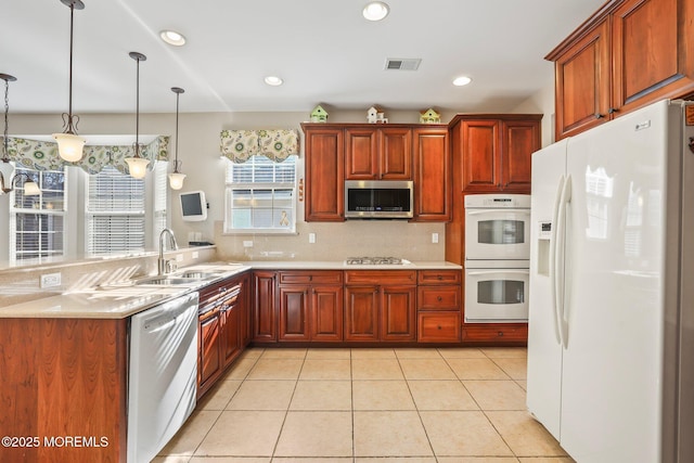 kitchen with a sink, recessed lighting, white appliances, light countertops, and light tile patterned floors