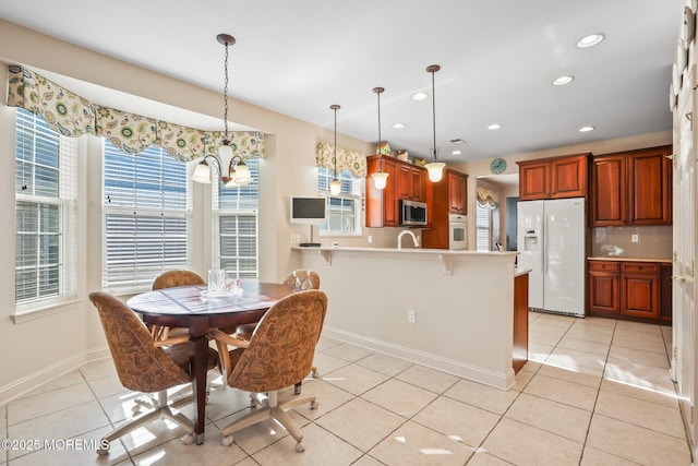 dining space with light tile patterned floors, baseboards, a healthy amount of sunlight, and recessed lighting