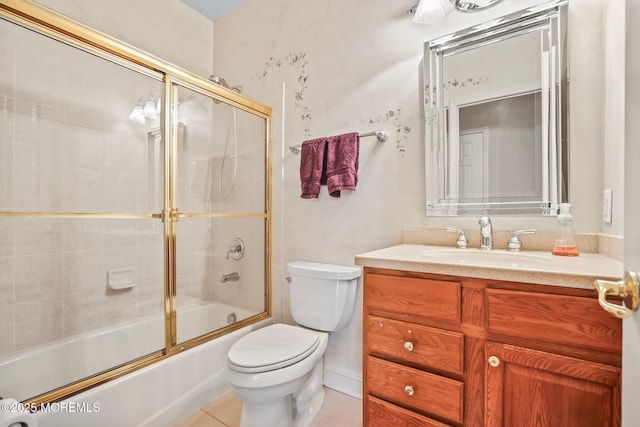 bathroom featuring tile patterned flooring, combined bath / shower with glass door, toilet, and vanity