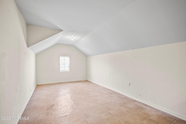 additional living space with lofted ceiling and baseboards