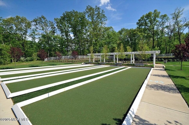 view of community featuring a yard and fence