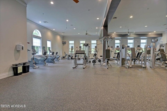 exercise room featuring plenty of natural light, ceiling fan, crown molding, and visible vents