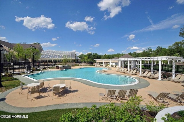 community pool featuring a patio area, a pergola, and fence