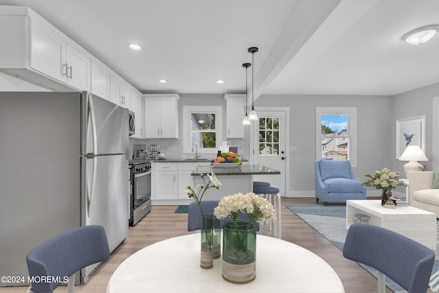 dining room featuring a healthy amount of sunlight, light wood finished floors, and recessed lighting