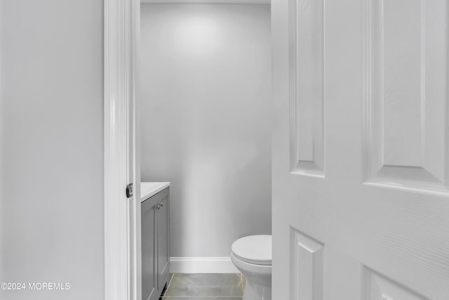 bathroom featuring baseboards, vanity, toilet, and tile patterned floors