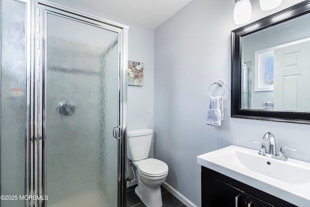 bathroom featuring toilet, a shower stall, baseboards, and vanity