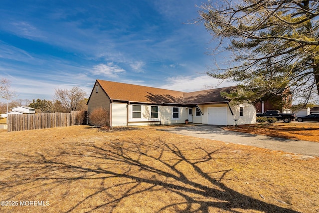 single story home with a garage, driveway, and fence