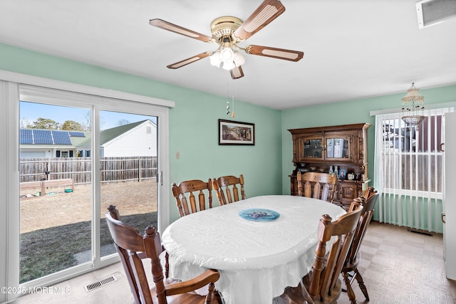 dining area featuring ceiling fan with notable chandelier, light floors, and visible vents