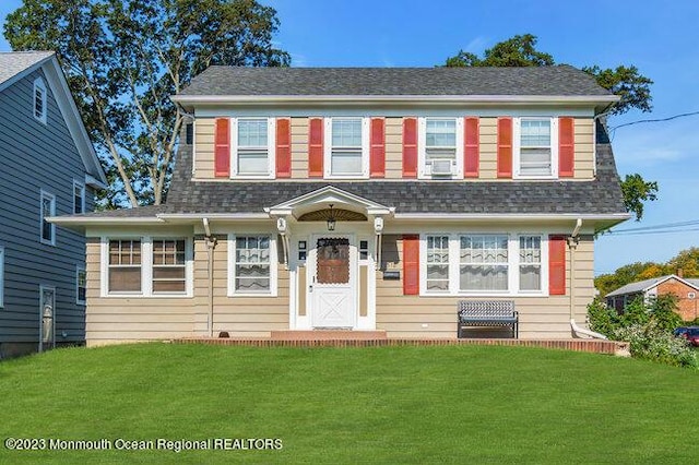 view of front of home featuring a shingled roof and a front lawn