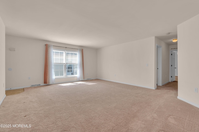 unfurnished room featuring light carpet, visible vents, and baseboards