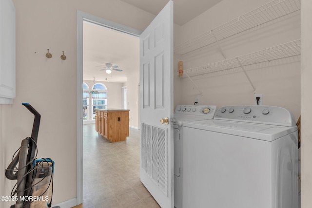 clothes washing area with baseboards, light floors, laundry area, a ceiling fan, and separate washer and dryer