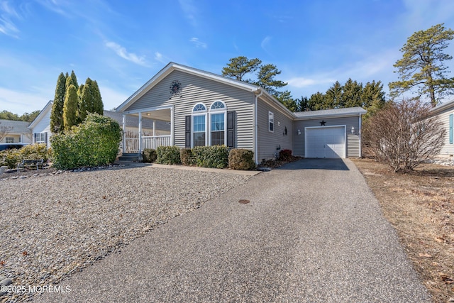 single story home with an attached garage, covered porch, and driveway