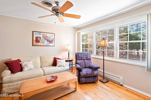 living area featuring a baseboard radiator, wood finished floors, and a ceiling fan