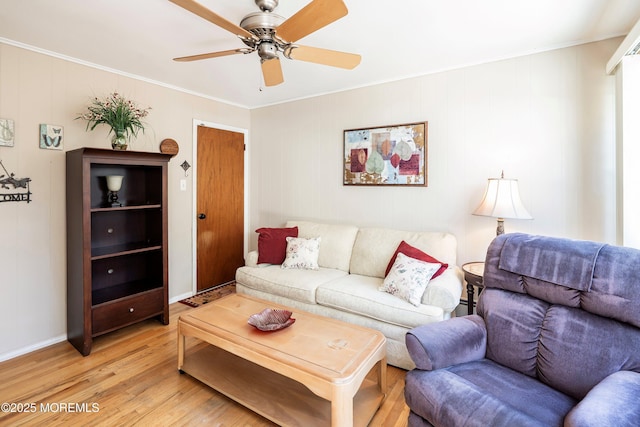 living area with baseboards, light wood finished floors, a ceiling fan, and crown molding