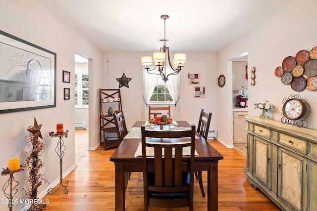 dining space with a wealth of natural light, light wood-type flooring, and a baseboard radiator