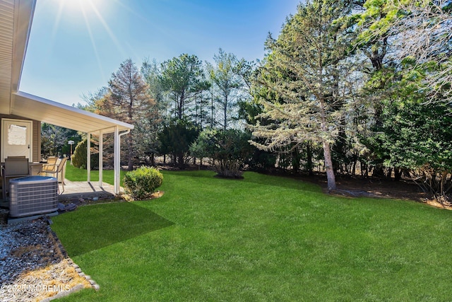 view of yard with cooling unit and a patio