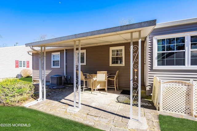 back of house with outdoor dining space, a patio, and central air condition unit