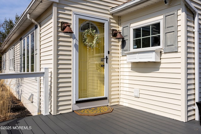 view of exterior entry with a wooden deck