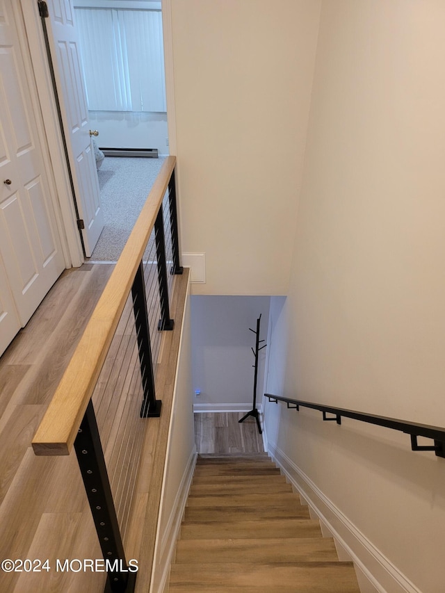 stairway featuring wood finished floors and baseboards