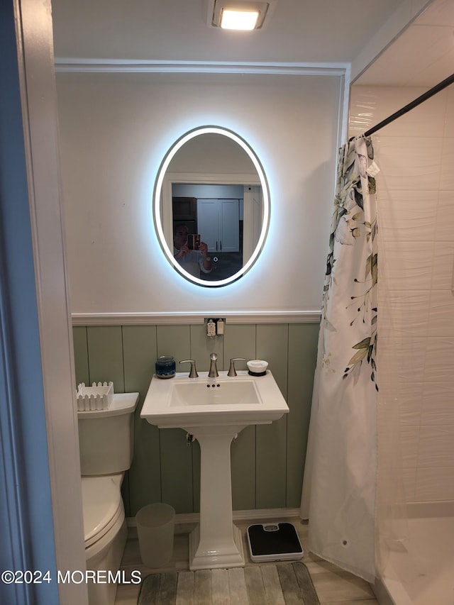 bathroom with a tile shower and toilet