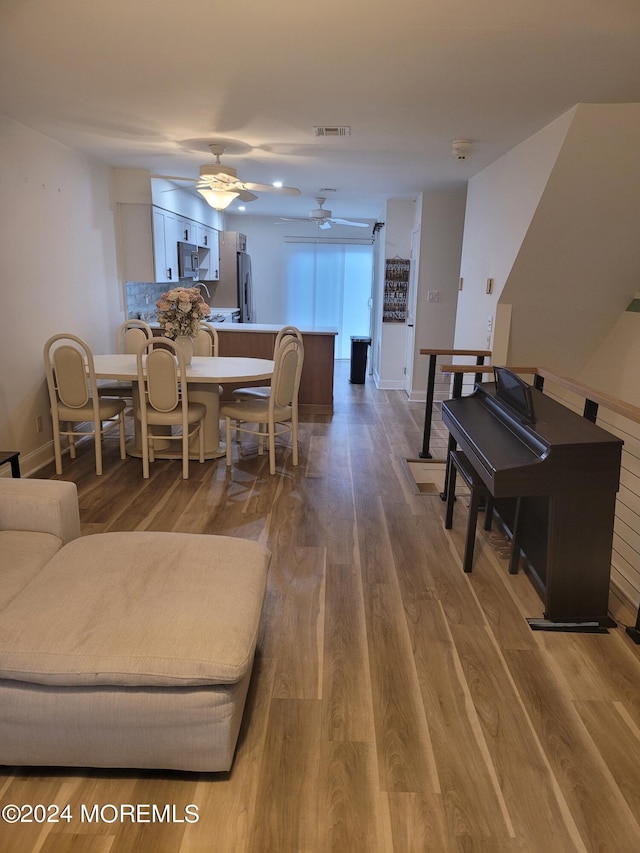 dining space featuring a ceiling fan, baseboards, visible vents, and wood finished floors