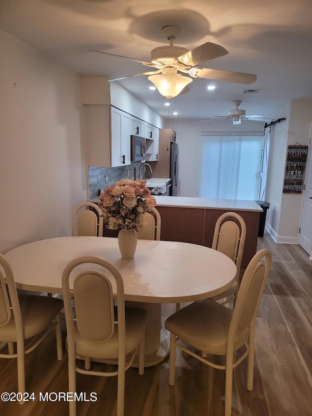 dining space featuring ceiling fan, dark wood-style flooring, and visible vents