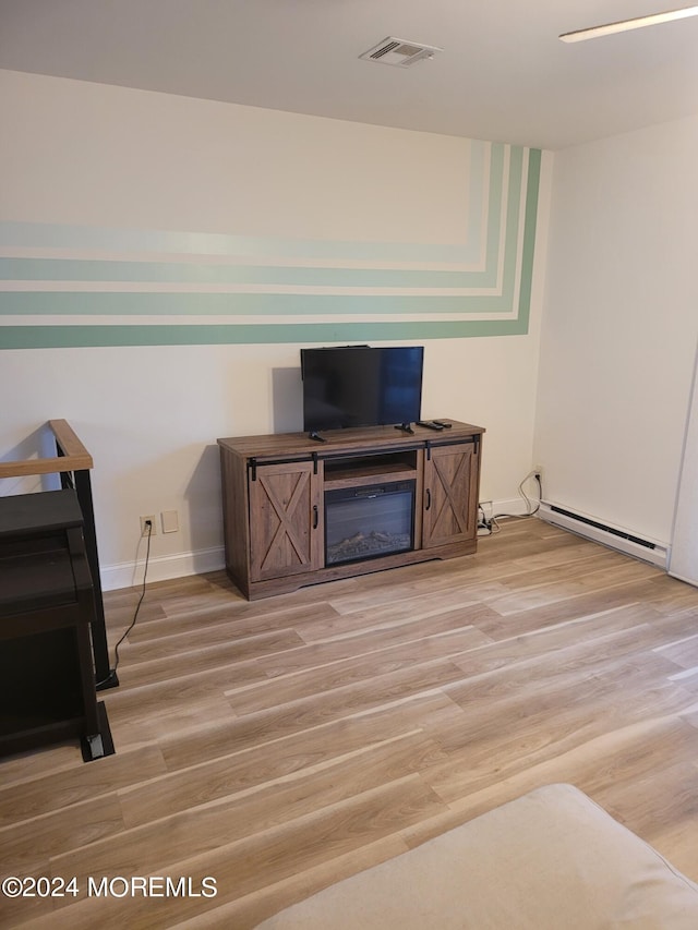 interior space featuring light wood-type flooring, baseboards, visible vents, and baseboard heating